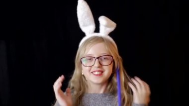 Paskalya tavşanı kulaklı, elinde lolipop tutan güzel bir genç kız. Ülke ahşap arka planı.