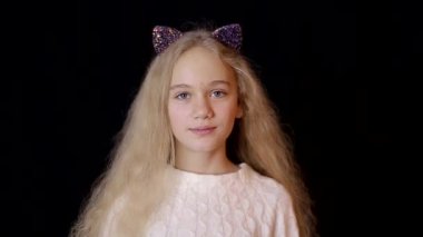 Kameraya bakan genç kız siyah bir arka planda izole edilmiş.