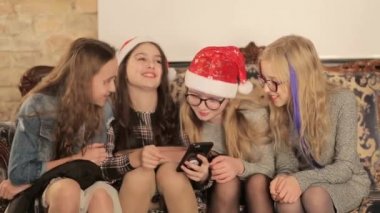 Bir grup küçük kız akıllı telefon kullanıyor.