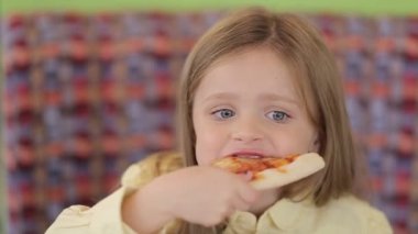 Küçük şirin Avrupalı bebek pizza yiyor. Pizzanın üstünde pizza yiyen aç bir çocuk..