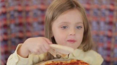 Küçük şirin Avrupalı bebek pizza yiyor. Pizzanın üstünde pizza yiyen aç bir çocuk..