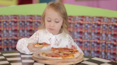 Küçük şirin Avrupalı bebek pizza yiyor. Pizzanın üstünde pizza yiyen aç bir çocuk..