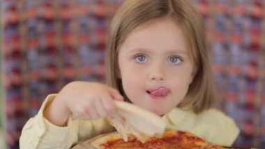 Küçük şirin Avrupalı bebek pizza yiyor. Pizzanın üstünde pizza yiyen aç bir çocuk..