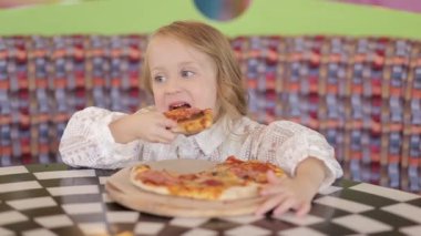 Küçük şirin Avrupalı bebek pizza yiyor. Pizzanın üstünde pizza yiyen aç bir çocuk..