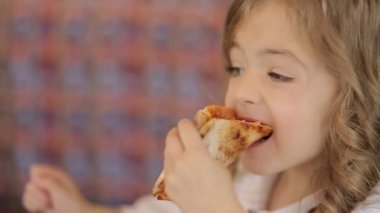 Küçük şirin Avrupalı bebek pizza yiyor. Pizzanın üstünde pizza yiyen aç bir çocuk..