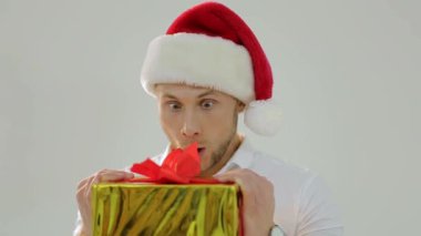 Noel satış konsepti. Küçük bir alışveriş arabası tutan mutlu noel adamı, noel hediyesi, izole edilmiş. Uzayı kopyala Yeni yıl tatili. Kış satışları. Noel Baba şapkalı gülümseyen adam alışveriş sepetiyle