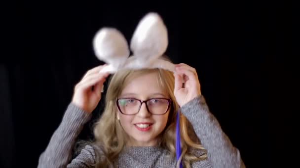 Menina muito adolescente com orelhas de coelho de Páscoa segurando pirulitos nas mãos. — Vídeo de Stock