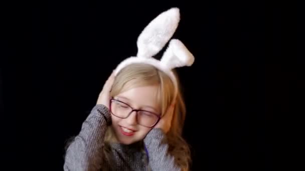 Hübsches Teenager-Mädchen mit Osterhasenohren hält Lutscher in den Händen. — Stockvideo