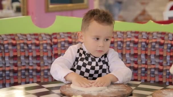 Piccola cuoca. I bambini fanno la pizza. Master class per bambini sulla cucina della pizza italiana. I bambini piccoli imparano a cucinare una pizza. Bambini che preparano pizza fatta in casa — Video Stock