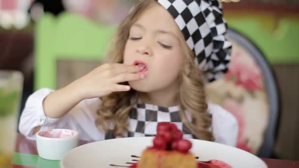 Bella bambina felice mordere torta di compleanno. Guardando la macchina fotografica . — Video Stock