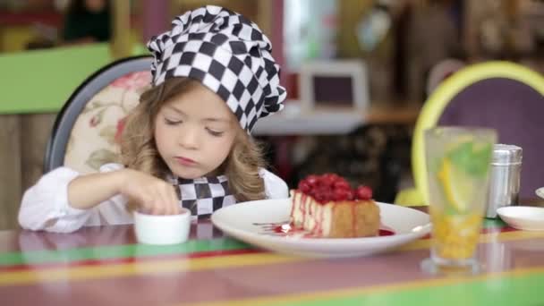 Niña feliz comiendo un pastel con sus manos, bebé comiendo un encantador pastel de Navidad — Vídeos de Stock