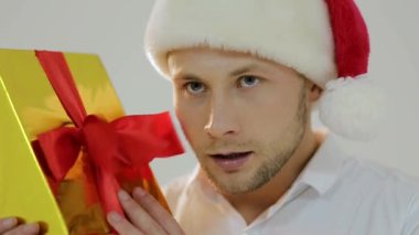 Noel satış konsepti. Küçük bir alışveriş arabası tutan mutlu noel adamı, noel hediyesi, izole edilmiş. Uzayı kopyala Yeni yıl tatili. Kış satışları. Noel Baba şapkalı gülümseyen adam alışveriş sepetiyle