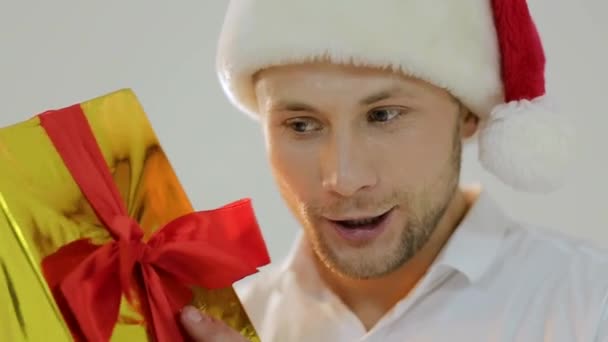サンタの帽子の男は、クリスマス プレゼントを保持します。クリスマス前に朝。配信クリスマス プレゼント。幸せなサンタ男。クリスマスのオンライン ショッピング。新年の木とプレゼントのシーン。冬の休日の販売. — ストック動画