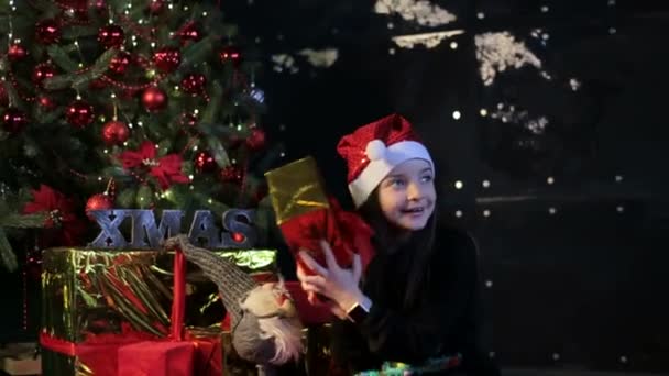 Con Feliz Navidad y Feliz Año Nuevo. Hermosa niña con un regalo en la atmósfera de Año Nuevo — Vídeos de Stock