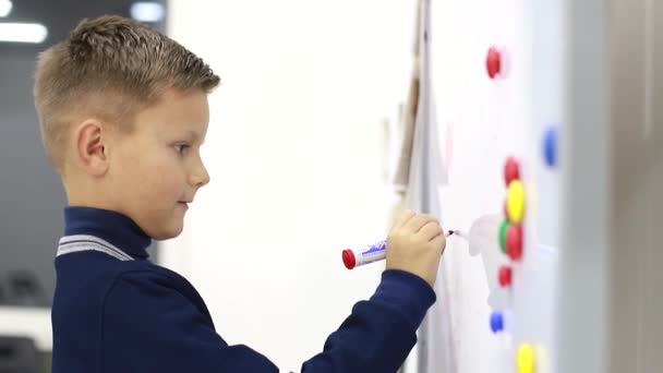 Fiú ír a táblán az iskolában, gyakorlatokat old meg. — Stock videók