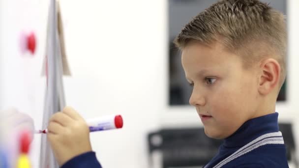 Jongen schrijven op schoolbord, oefeningen oplossen — Stockvideo