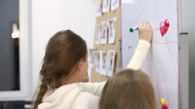 İlkokul çocuğu ilkokulda tahtaya kalp işareti çizmiş..