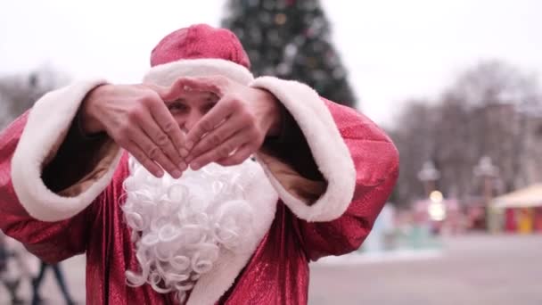 Der Weihnachtsmann zeigt eine herzliche Geste der Güte und Liebe und blickt in die Kamera. — Stockvideo