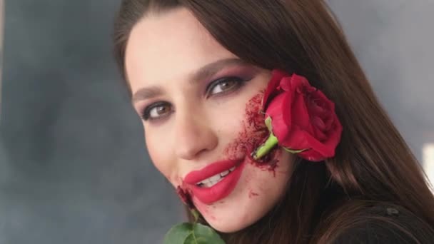 Porträt eines Mädchens mit einer roten Rose im Mund. Make-up für Halloween, Rosenblume im Mund.