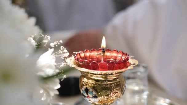 Ένα όμορφο κερί σε ένα χρυσό κηροπήγιο καίγεται στην εκκλησία. Πίστη στο Θεό — Αρχείο Βίντεο