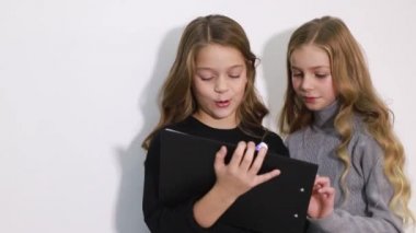 Okulda okumak için tablet kullanan iki zeki çocuk..