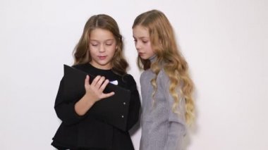 Okulda okumak için tablet kullanan iki zeki çocuk..