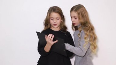 İki güzel kız kardeş tablet ekranına bakın, akıllı çocuklar akıllı teknolojiyi kullanıyorlar..