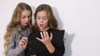 İki güzel kız kardeş tablet ekranına bakın, akıllı çocuklar akıllı teknolojiyi kullanıyorlar..