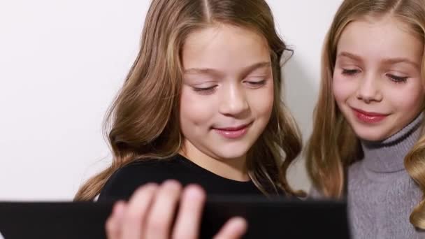Zwei intelligente Kinder lernen in der Schule mit einem Tablet. — Stockvideo