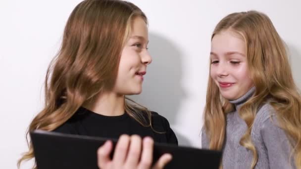 Δύο έξυπνα παιδιά χρησιμοποιούν ένα τάμπλετ για να σπουδάσουν στο σχολείο. — Αρχείο Βίντεο