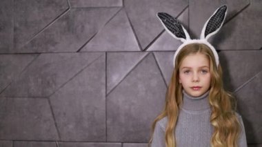 Kulak takmış şirin bir kızın portresi. Paskalya tavşanı.