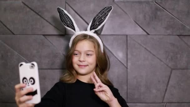 즐거운 어린 소녀, 토끼 귀를 가진 사진을 찍는다 — 비디오
