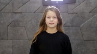 Uzun, şık, pahalı elbisesi olan okul çağındaki mutlu küçük bir kız.