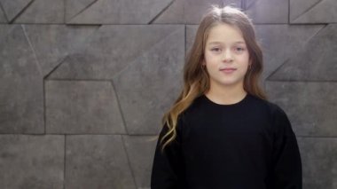 Uzun, şık, pahalı elbisesi olan okul çağındaki mutlu küçük bir kız.