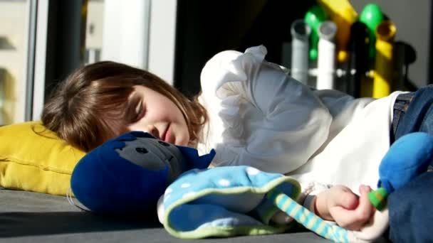 Cute little girl śpi w swoim małym łóżku, przytuliła miękką zabawkę — Wideo stockowe