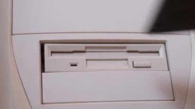Retro bilgisayara disket yükleme yakın plan. Disket taraması. Retro bilgisayar 90 yıl