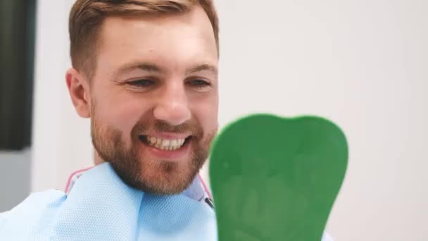 Glücklicher Patient Der Zahnarztstuhl Sitzt Den Spiegel Schaut Und Lächelt — Stockvideo