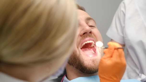 Kadın Dişçi Dişçi Muayenehanesinde Genç Bir Adamın Dişlerini Tedavi Ediyor — Stok video