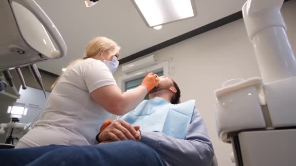 歯医者は患者の歯を治療するために歯科器具を使う 現代の歯科と医療の概念 ペイン歯科治療 — ストック動画