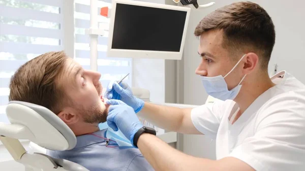 Een Mannelijke Tandarts Behandelt Een Patiënt Tanden Pijnloze Tandheelkundige Behandeling — Stockfoto