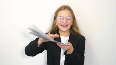 Beyaz tişörtlü kız parayı beyaza saklamış. Finansal iş kavramı. Elinde dolar olan bir çocuk, 4K video.