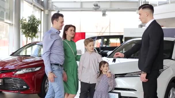 快乐的家人买新车 汽车经销商和爸爸握手祝贺家人买新车 4K视频 — 图库视频影像