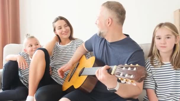Familia Feliz Relajarse Casa Sentado Sofá Papá Tocando Guitarra Para — Vídeos de Stock