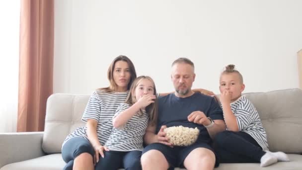 Οικογένεια Μπαμπάς Και Παιδιά Τρώνε Ποπ Κορν Και Βλέπουν Τηλεόραση — Αρχείο Βίντεο