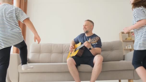 Papà Suona Chitarra Mentre Seduto Sul Divano Sua Famiglia Seduta — Video Stock