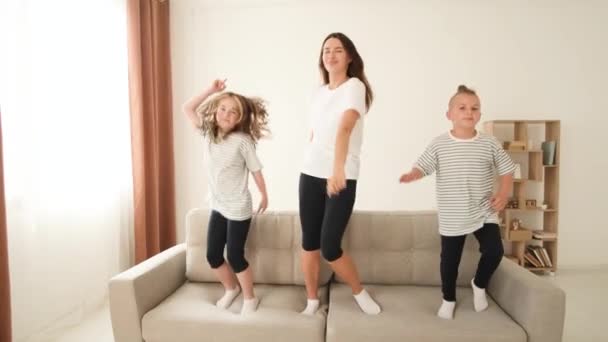 Mãe Brinca Com Crianças Elas Pulam Sofá Divertem Abraçam Família — Vídeo de Stock