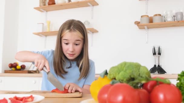 一个少女在厨房里做饭 她切红辣椒 快乐的少女在厨房帮妈妈 小孩准备新鲜蔬菜 — 图库视频影像
