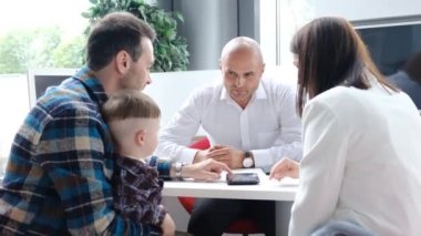 Geniş bir aile bankadan ipotek alır, krediyle ev alır. Bir banka çalışanı müşterilere tavsiyede bulunur. Borç verme ve banka kavramı