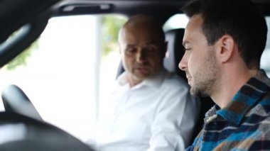 Bir araba satıcısı genç bir adama araba satar. Satış müdürü içeride oturan yeni arabadan bahseder, alıcı galeriden bir araba seçer. Halk ve iş kavramı.