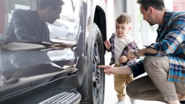 Happy Owner New Car Inspects Showroom His Young Son Young — Stock Video